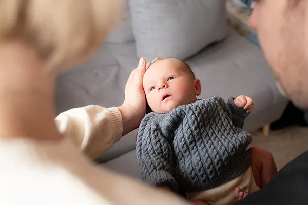 Eltern schauen im Shooting Newborn München auf ihr Baby