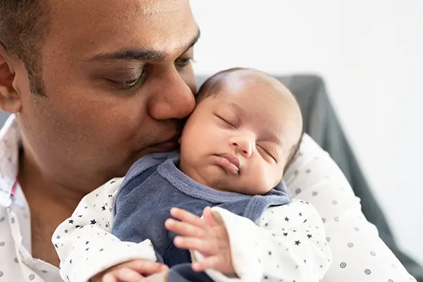 Stolzer Papa mit Baby im Babyfotoshooting