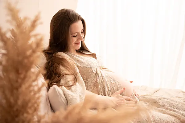 Mama mit Kind im Babybauch Shooting zuhause
