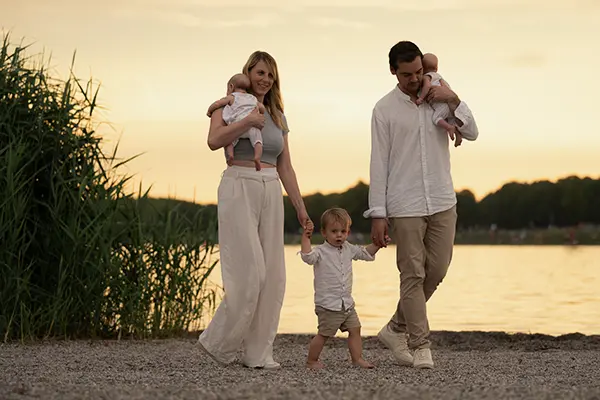 Familie mit Kind und Babys spaziert am See