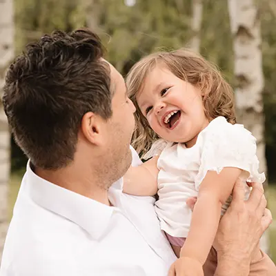 Familienfotografie München Papa trägt sein Kind auf dem Arm Familienfotografie München Papa trägt sein Kind auf dem Arm