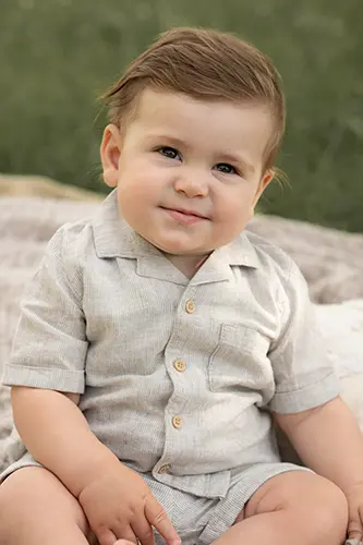 Junge freut sich im Kinderfotoshooting auf der Decke