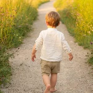 Junge spaziert im Grünen im Familien Fotoshooting draußen