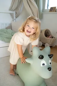 Mädchen hat Spaß im Kinder Fotoshooting München auf dem Hüpfetier