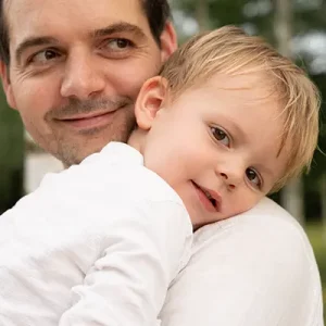Papa trägt den Jungen auf dem Arm im Familienfotoshooting