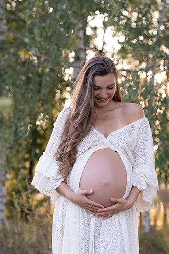 Schwangere schaut im Shooting Schwangerschaft verliebt auf ihren Bauch Schwangere schaut im Shooting Schwangerschaft verliebt auf ihren Bauch