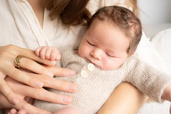 Mama hat Baby im Shooting Newborn auf dem Arm