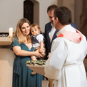 Eltern mit dem Pastor begleitet durch einen Taufe Fotograf München