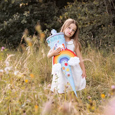 Mädchen mit Schultüte macht Quatsch im Fotoshooting Einschulung Familie
