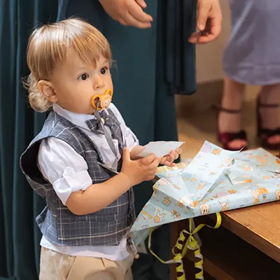 Taufe Bilder Fotograf Junge packt Taufgeschenk aus