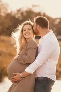 Verliebtes Paar im Babybauch Shooting im Park