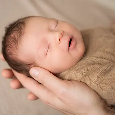 Baby auf dem Arm im Newborn Fotoshooting München