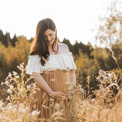 Baby bump shooting poses outside on the field