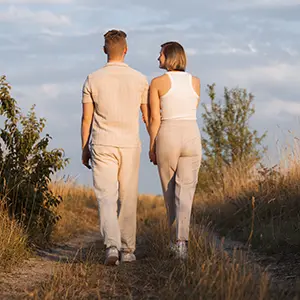 Paar spaziert im Verlobungs Fotoshooting München draußen in der Natur