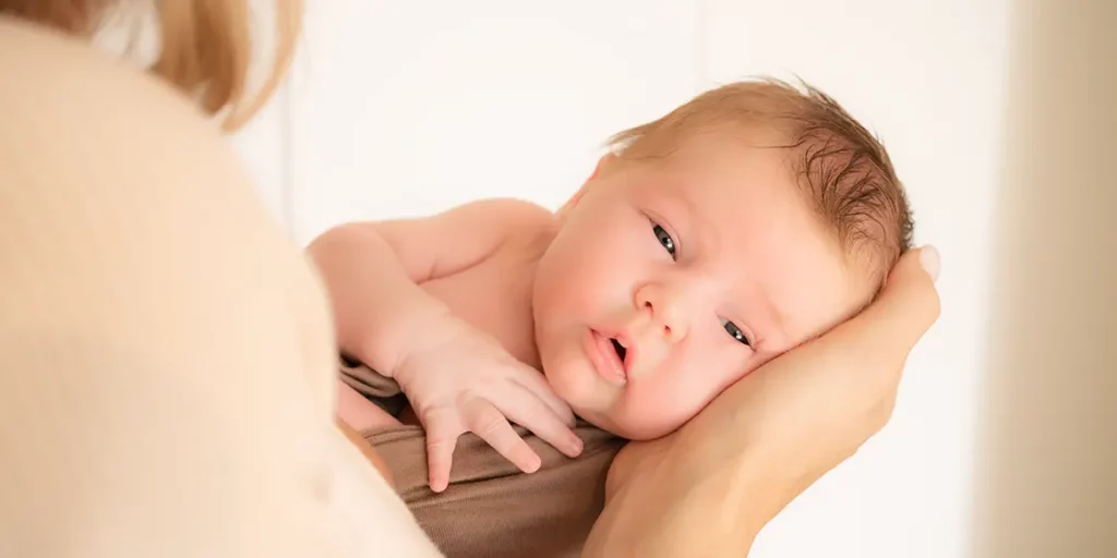 Sicherheit Newborn Shooting Frau trägt Baby auf dem Arm