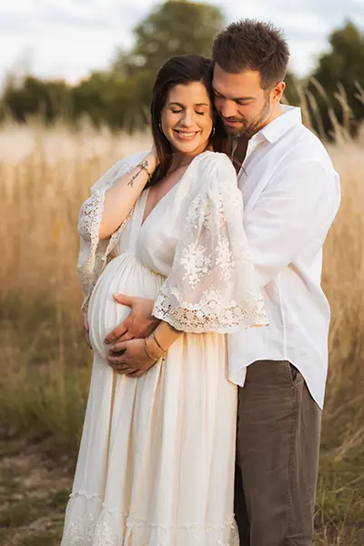 Umarmung im Sonnenlicht im Schwangerschaftsshooting München