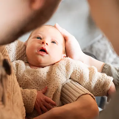 Eltern schauen auf ihr Neugeborenes im Newborn Fotoshooting München