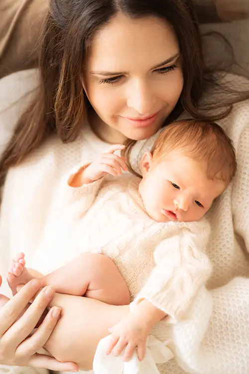 Mother with child in sunlight in newborn photography Munich at home