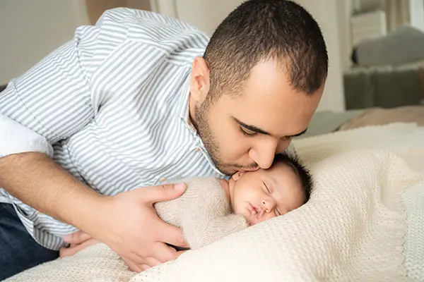 Papa kuschelt mit seinem Baby im Neugeborenenshooting in München