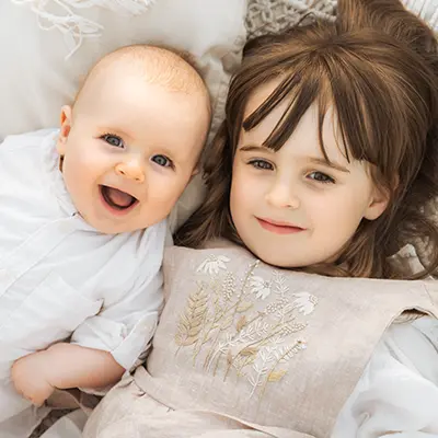 Geschwister lachen im Babyshooting outdoor in München