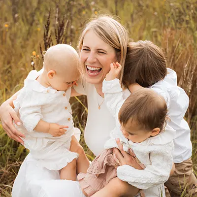 Mutter mit ihren Kindern auf der Wiese im Babyshooting München Mutter mit ihren Kindern auf der Wiese im Babyshooting München