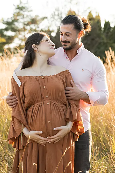 Paar schaut sich in der Schwangerschaftsfotografie outdoor auf der Wiese an