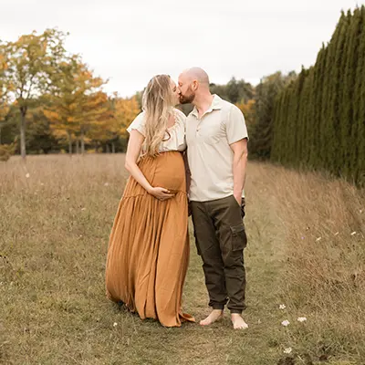 Paar spaziert auf der Wiese im Schwangerschaft Fotoshooting in München