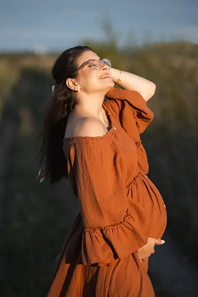 Schönes Licht Schwangere im Terrakotta Schwangerschaftskleid