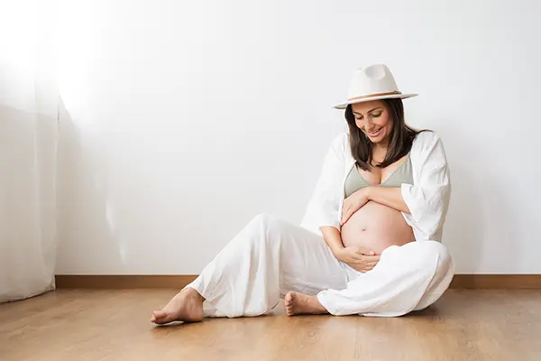 Schwangere mit Hut im Indoor Studio Babybauchshooting