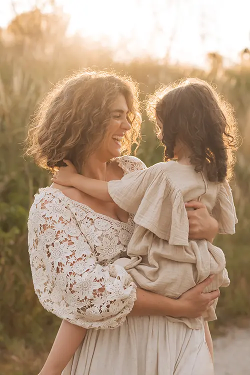 Mutter lacht mit ihrem Kind in der Sonne im Familien Shooting in München outdoor Mutter lacht mit ihrem Kind in der Sonne im Familien Shooting in München outdoor