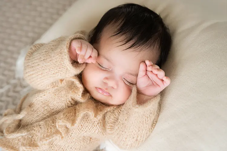 Zartes Baby mit schwarzen Haaren schläft im Fotoshooting mit Baby Zartes Baby mit schwarzen Haaren schläft im Fotoshooting mit Baby
